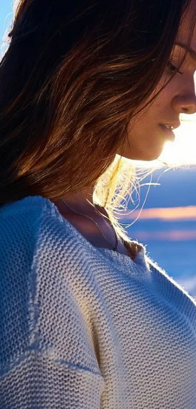 Young woman in sweater at sunset, serene mobile wallpaper.