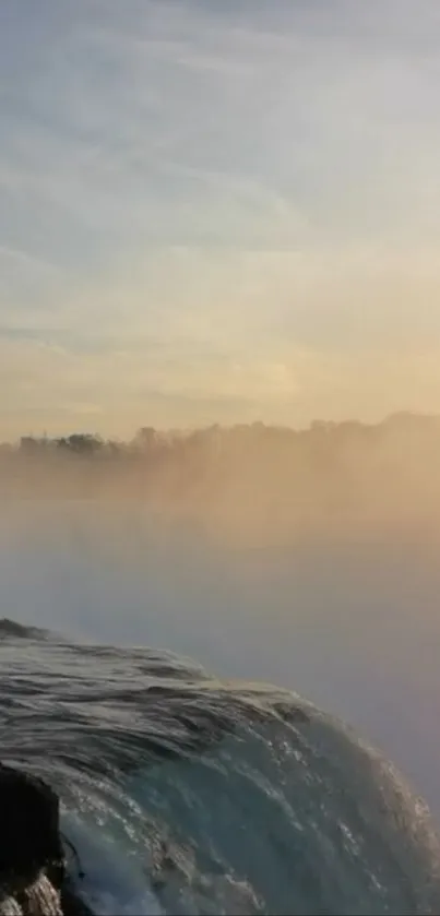 A serene waterfall at sunset with misty hues of orange and blue.