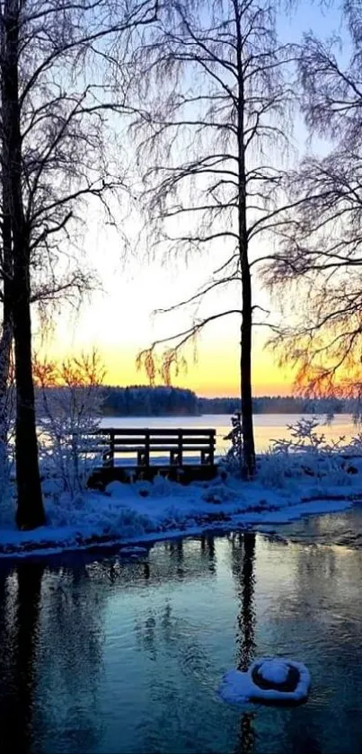 Serene winter sunset over frozen lake with frosty trees.