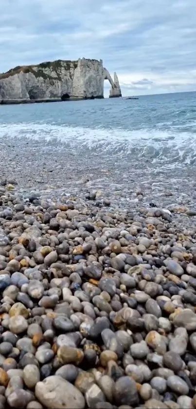 Pebble beach leading to cliffs by the ocean.