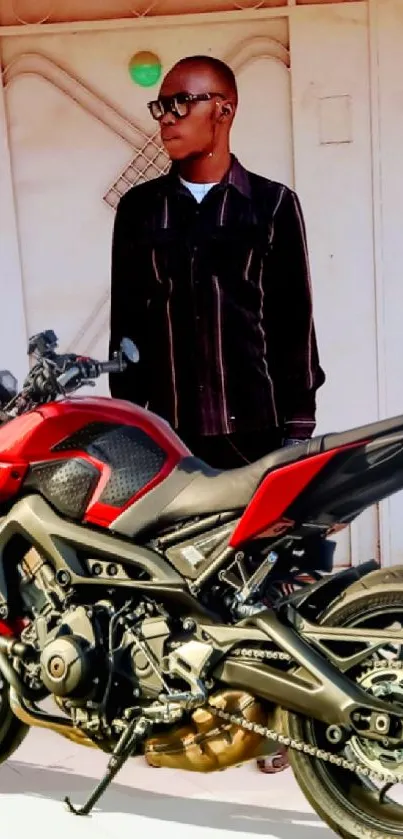 Person standing beside a red motorcycle.