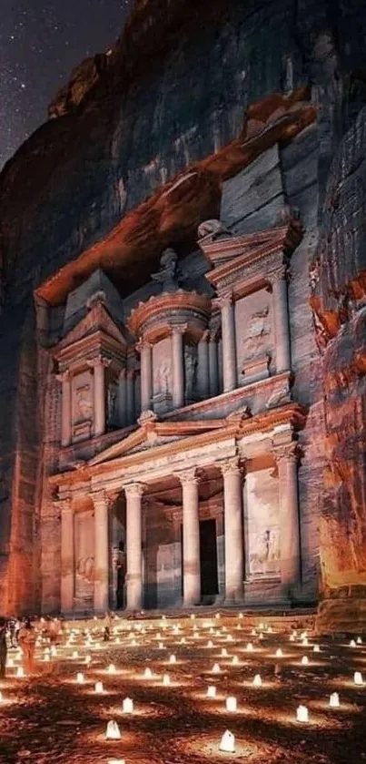 Night view of Petra lit by candles with a dramatic rocky backdrop.