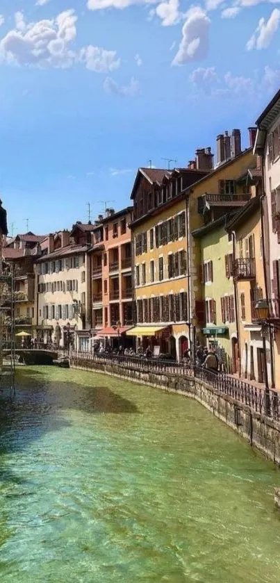 Charming canal and colorful buildings under blue sky.