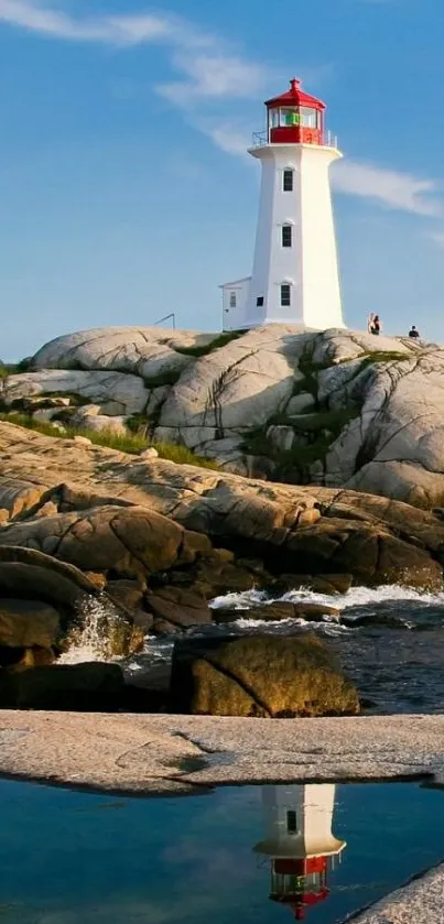 Serene lighthouse on rocky coast under blue sky.