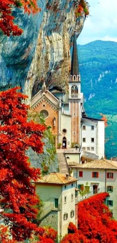 A stunning mountain chapel framed by red autumn leaves.