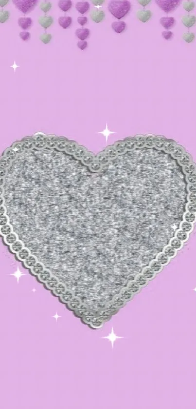 Silver glitter heart on pink background.