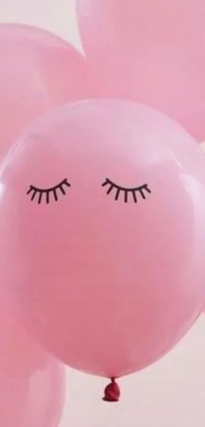 Pink balloons with cute sleepy faces on a soft background.