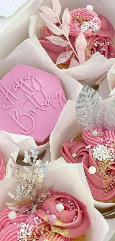 Pink cupcakes with elegant frosting and birthday decor in a box.