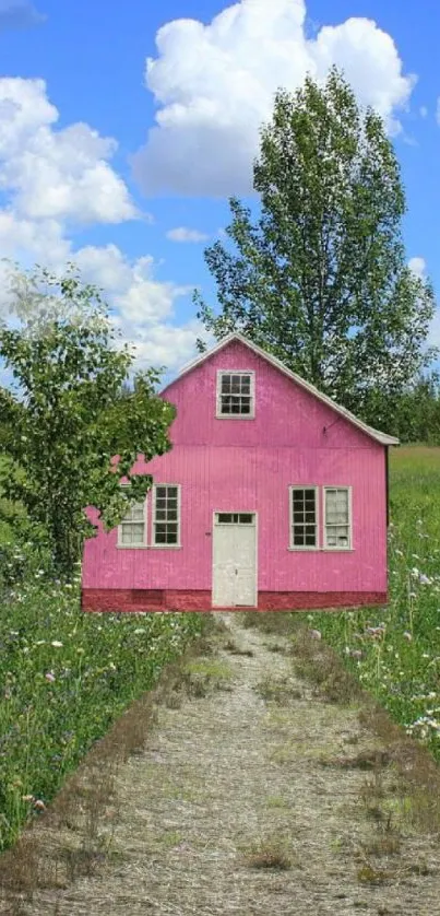 Pink cottage on a green field with a blue sky background wallpaper.