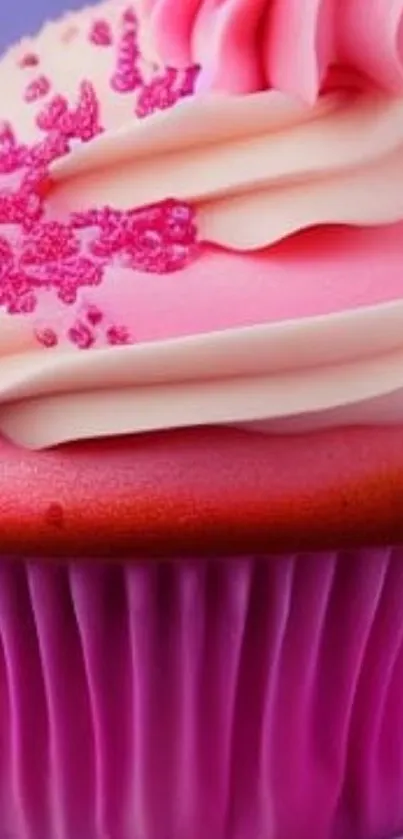 Pink cupcake with frosting and sprinkles on a purple background.