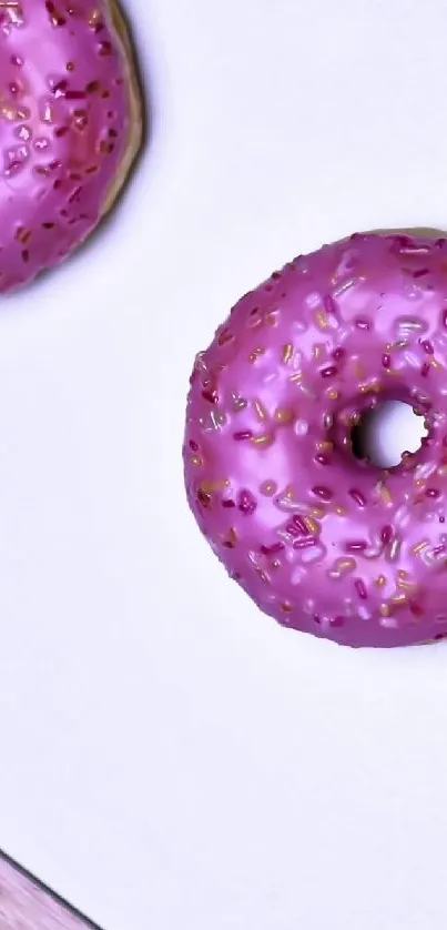 Pink frosted donuts with sprinkles on a white background