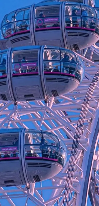 Pink Ferris wheel with blue sky, artistic cityscape view.