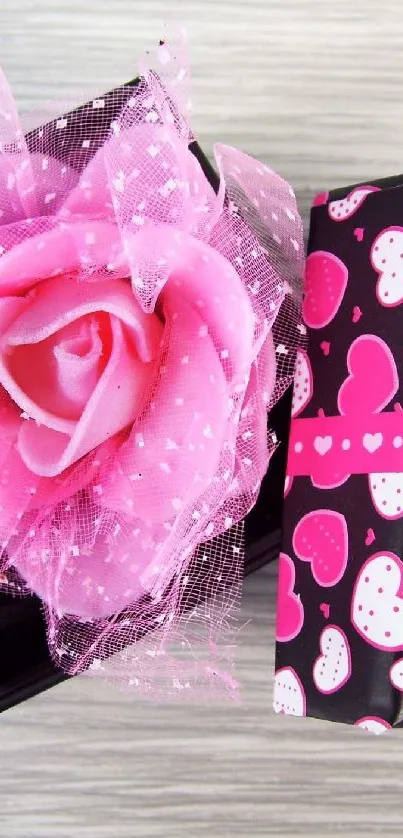 Pink rose gift box with heart pattern on soft background.