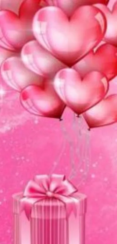 Pink heart balloons floating above a gift box on a decorative pink background.