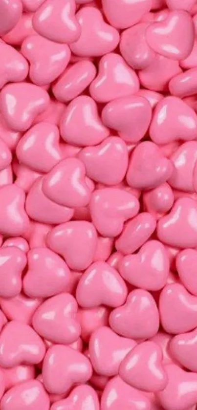 Mobile wallpaper with pink heart-shaped candies.