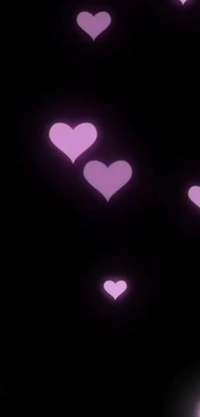 Pink hearts glowing on a black background, creating a romantic mobile wallpaper.