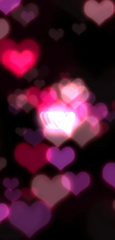 Pink neon heart with glow effect on black background wallpaper.