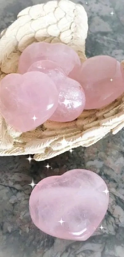 Rose quartz heart stones in a shell on a textured background.