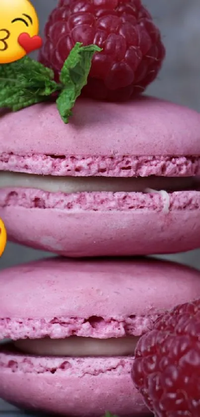 Pink macarons stacked with raspberries and emojis, artistic mobile wallpaper.