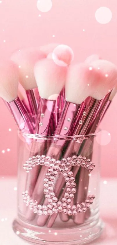 Elegant pink makeup brushes in a stylish glass container.