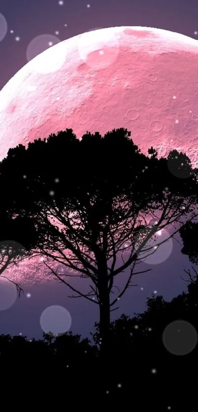 Vibrant pink moon with silhouetted trees against night sky.