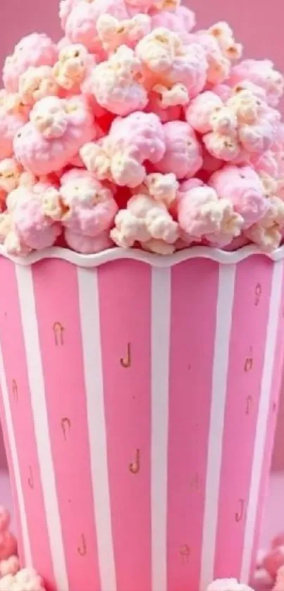 Pink popcorn in a striped container on pink background.