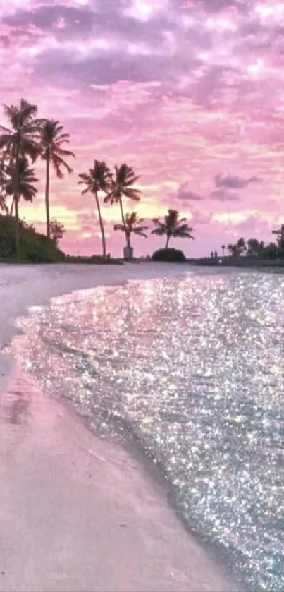 Pink sunset beach with palm trees and sparkling ocean.