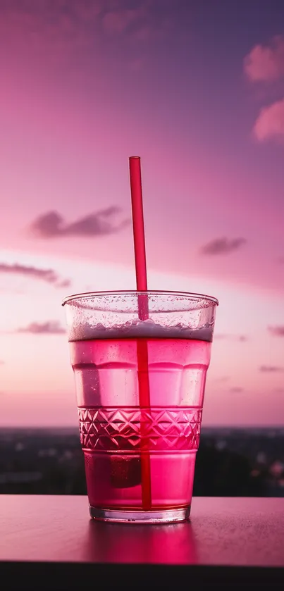 Vibrant pink drink with sunset background.