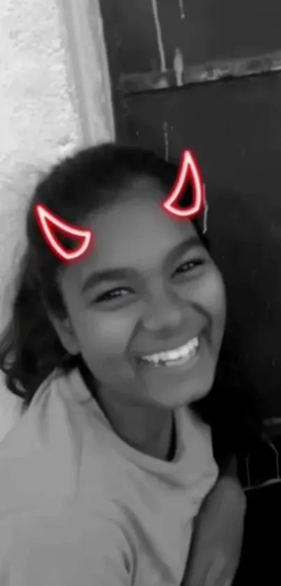 Smiling girl with neon red doodle horns in black and white.