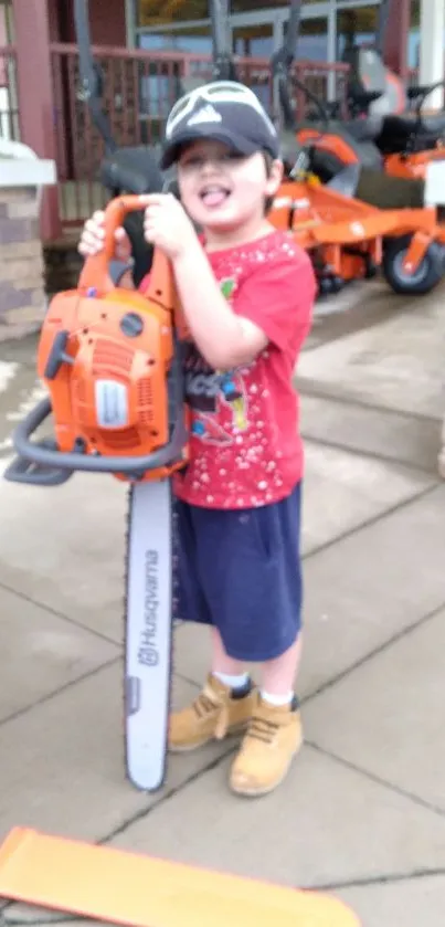 Child in red shirt holding a toy chainsaw with orange hues.