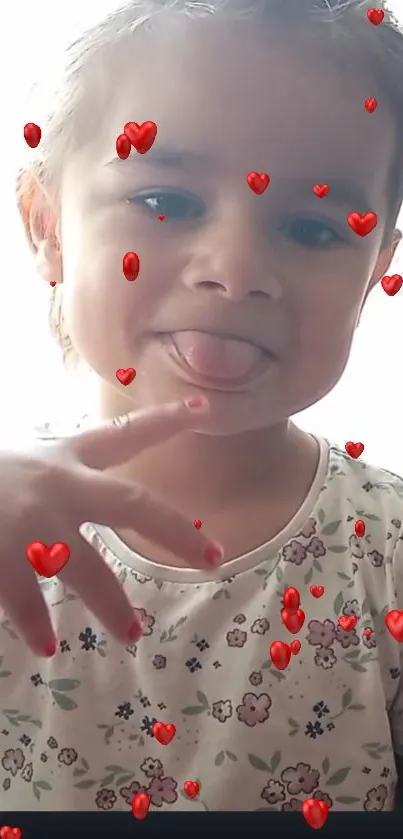 Playful child with tongue out and floating red hearts.