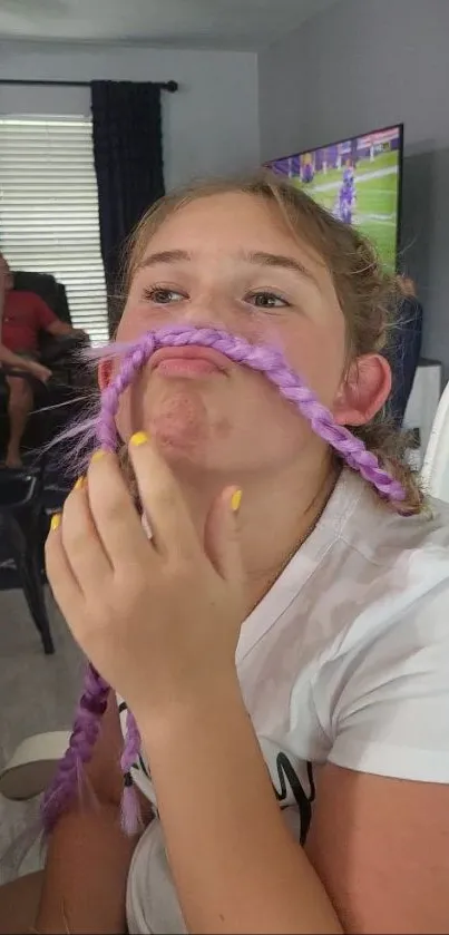 Girl with purple braided mustache being playful.