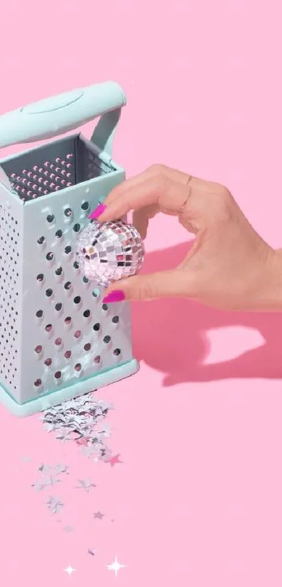 Hand with disco ball and grater on pink background.