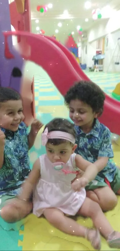 Three children playing at indoor playground with colorful backgrounds.