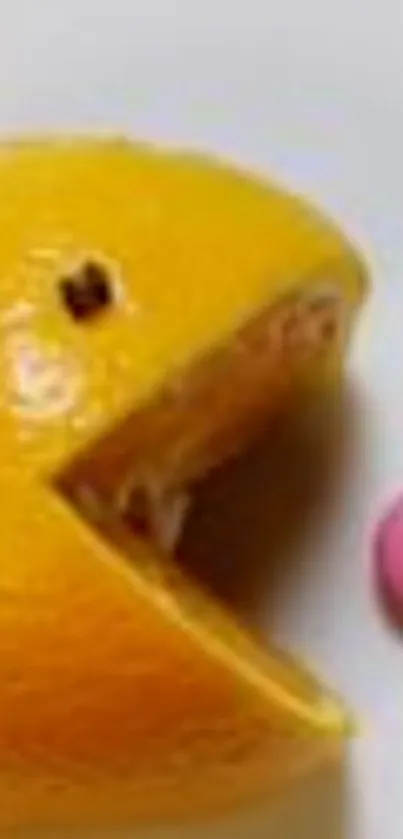 Orange slices resemble Pac-Man with candy on a plate.