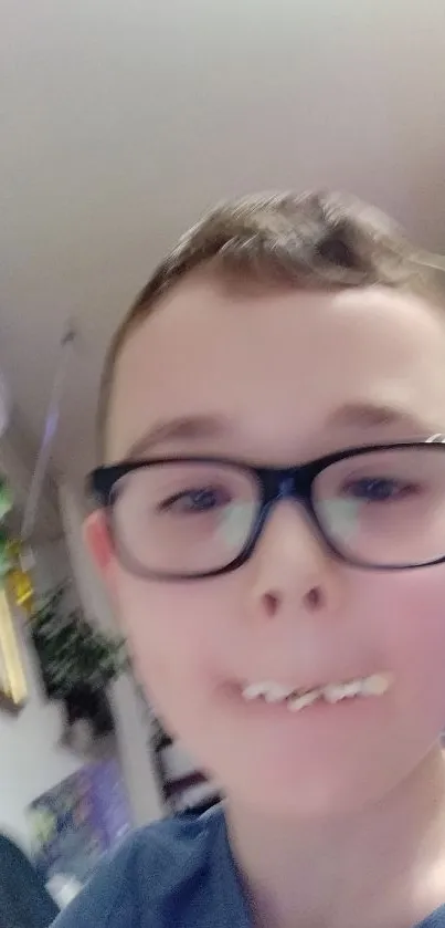 A young boy with glasses eats a snack playfully indoors.