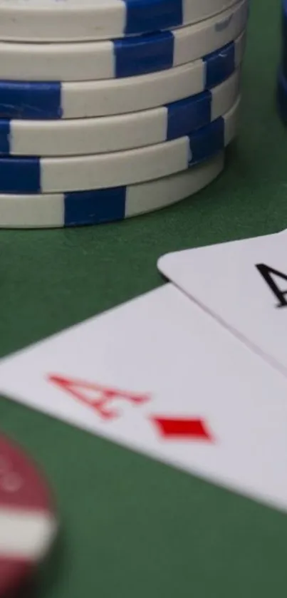 Poker chips and playing cards on a green table.