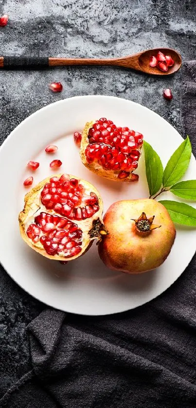 Pomegranate and seeds on a white plate with dark textured background.