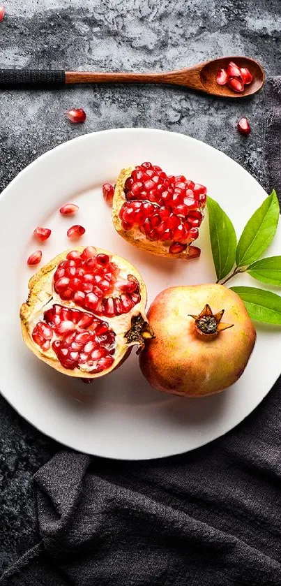 Pomegranate and leaves on white plate with dark cloth background.