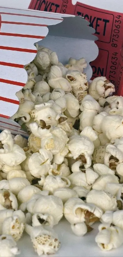 Overflowing popcorn and red movie tickets.