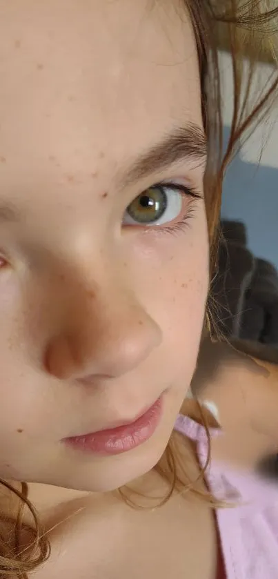 Close-up portrait wallpaper with expressive eyes and freckles.