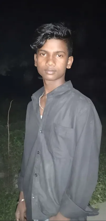 Young man in a dark, serene nighttime portrait.