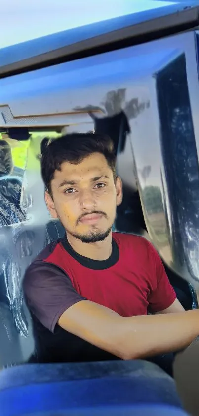 Man seated in a vehicle interior with a serene expression.