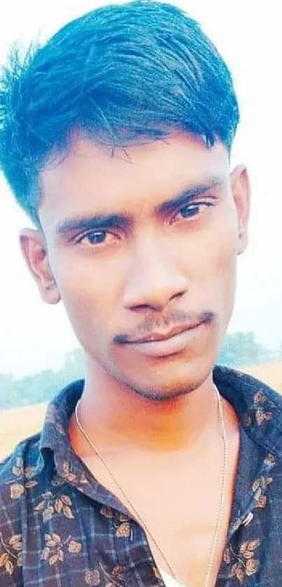 Portrait of a man in a sunny rural field.