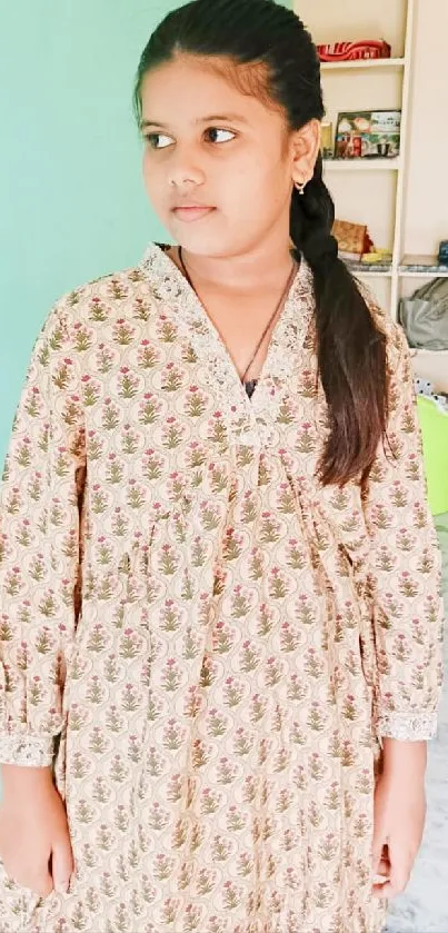 Portrait of a young girl in floral dress indoors.