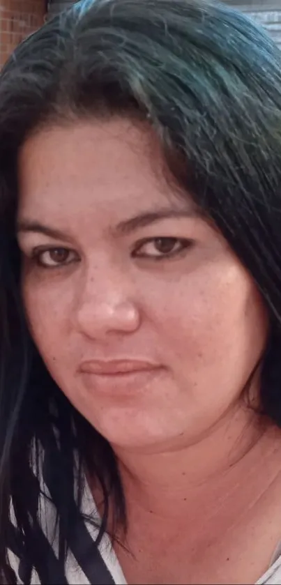 Close-up portrait of a thoughtful woman with dark hair and a serene expression.