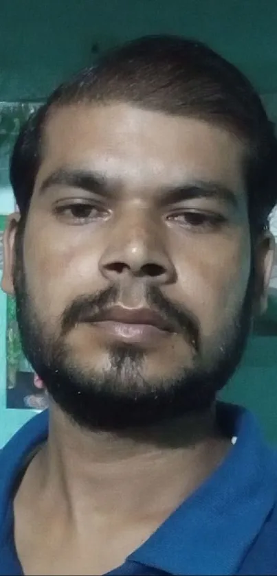 Portrait of a man in a blue shirt indoors.