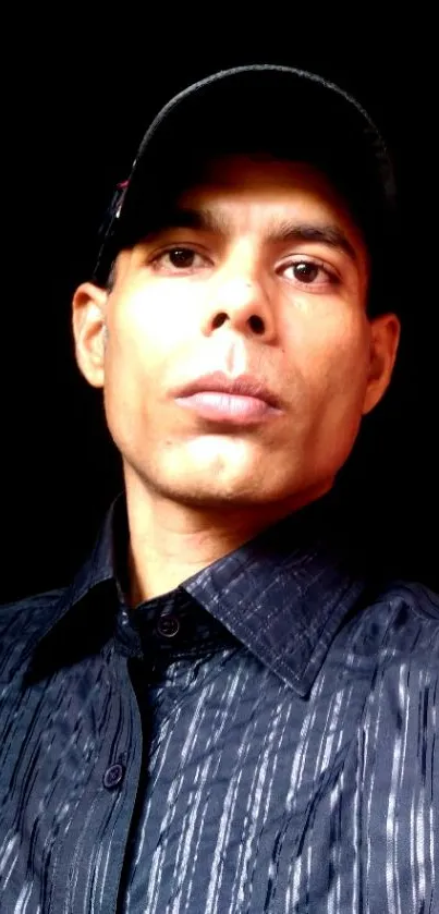 Portrait of person wearing a stylish black shirt with a dark background.