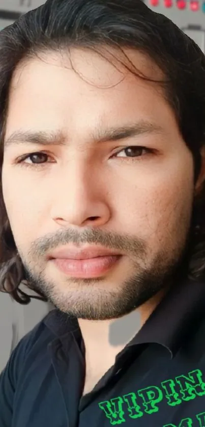 Bearded man portrait with dark hair against a modern background.