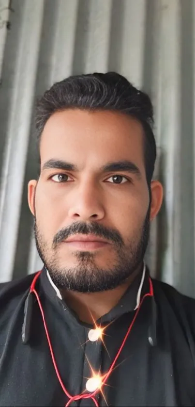 Man in black shirt with metallic background.